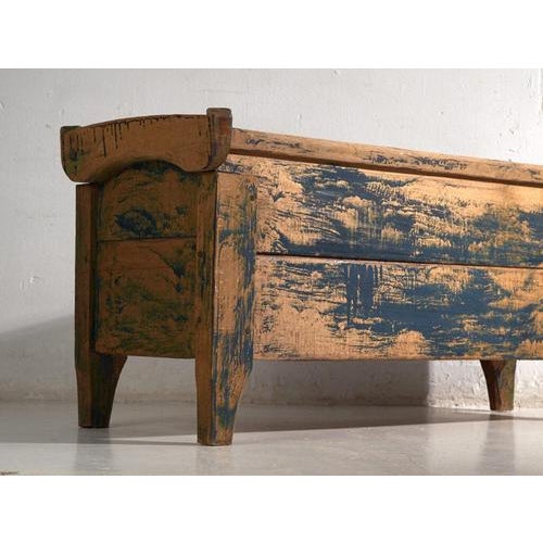 This antique blue-painted chest in pine wood is a Central European peasant chest with shaped end boards and splayed feet....
