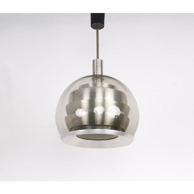 Doria Leuchten smoked glass pendant lamp produced in the 1960s. This beautiful Space Age pendant lamp is a real eye-...