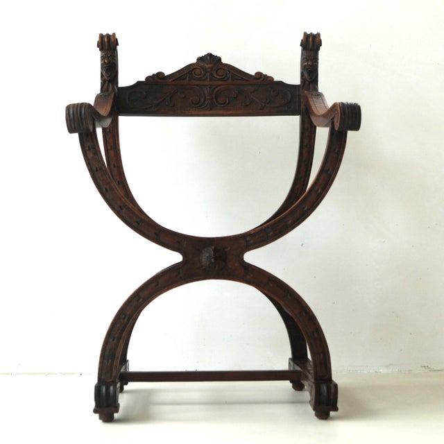 Decorative woodcarved curule armchair, also known as Dagobert chair. It has a lovely patina and is in good condition, very...