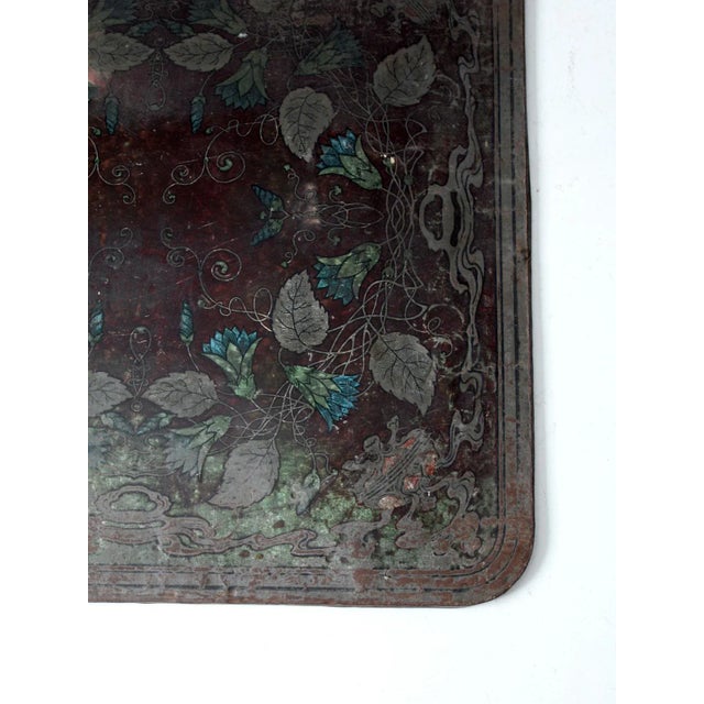 An antique stove board by the Wabash Screen Door Company from the early 20th century. The tin surface features a...