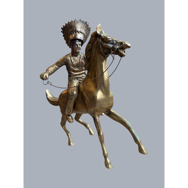 Offering a vintage brass sculpture of a Native American chief riding a horse capturing an action fast running display. The...