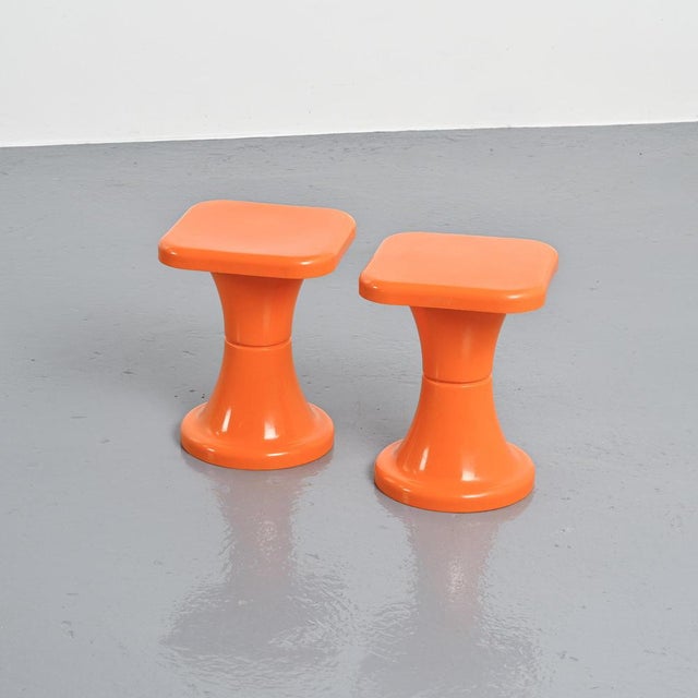 Pair of orange plastic stools produced by S.E.L.U.P., France, circa 1970. Each stool features a molded, Space Age-inspired...