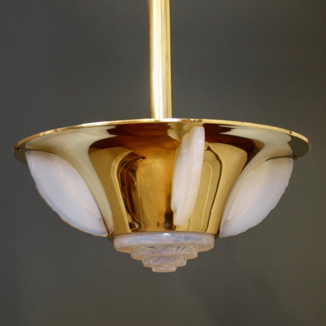 This round Art Deco chandelier, likely from Jean Perzel of Paris, is made of polished brass and features four vertical...