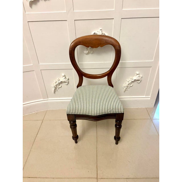 A lovely set of four antique Victorian mahogany balloon-back dining chairs with elegant lines and a warm, well-preserved...