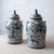 A pair of Chinese blue and white glazed stoneware jars, each with a domed lid surmounted by a seated Buddhist lion, or foo...