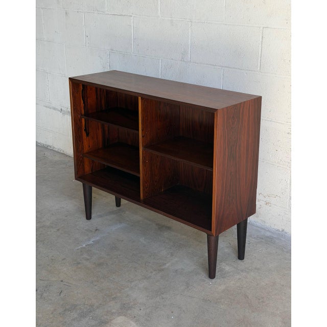 Beautiful vintage Scandinavian Modern bookcase crafted in richly grained rosewood in Denmark. This elegant open shelving...