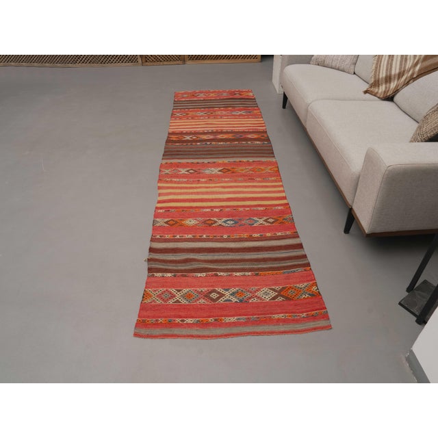 Vintage Hand-Knotted runner rug is a semi-antique vintage area rug. The '70s Eastern region of Anatolia's unique rug is...