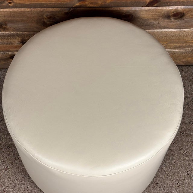 Handcrafted in the USA, this elegant round ottoman is upholstered in premium Italian leather for a sophisticated addition...