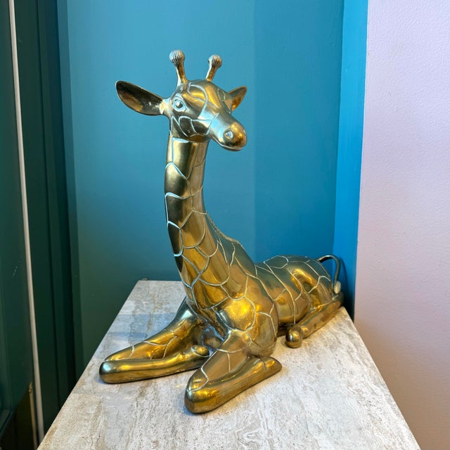 A gorgeous large brass giraffe with elegant detailing throughout. Dimensions: 18.5”L x 7”W x 15.75”H