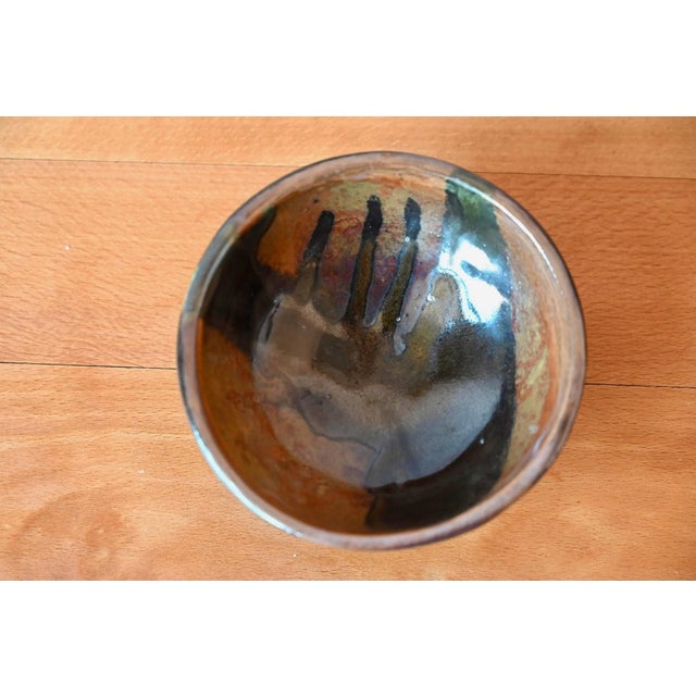 This lovely glazed stoneware bowl dates from the 1970s. Its shape is gentle and its glaze warm. Black on the outside, the...