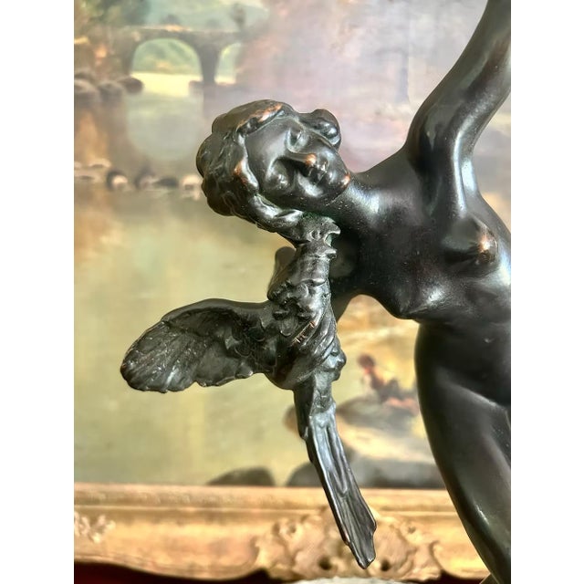 A graceful antique bronze-clad sculpture by the Pompeian Bronze Company depicting the celebrated Danseuse aux Aras (Dancer...