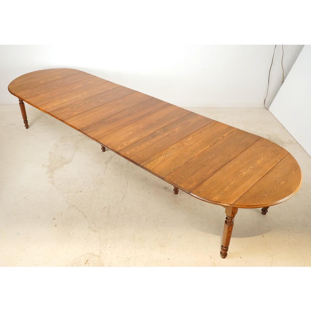 Vintage Traditional style dining table in medium toned wood with six turned legs. Can be used as a 25.5 in. drop leaf...
