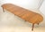Vintage Traditional style dining table in medium toned wood with six turned legs. Can be used as a 25.5 in. drop leaf...