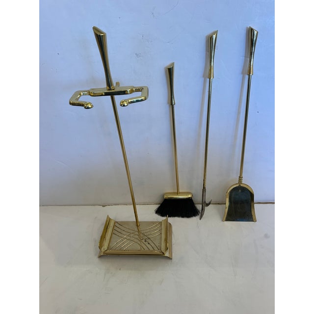 Very chic sophisticated brass mid century modern fireplace tools having 3 tools with stylized handles.