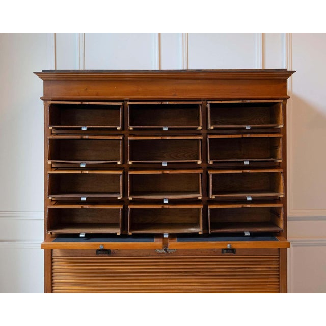 An early 20th-century Italian wooden filing cabinet, dating to the early 1900s, combining functional design with...