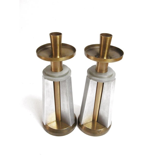 Discover a remarkable pair of Machine Age (1940s) Mid-Century Modern candle holders crafted from solid aluminum and brass....