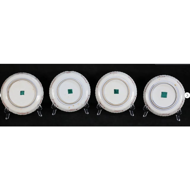 A beautiful set of four antique Japanese Kutani porcelain plates, each hand-painted with birds perched among bamboo,...