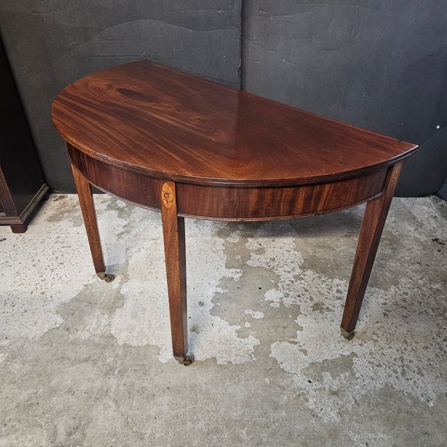This is a very pretty Mahogany Inlaid Georgian Demi-Lune Console Table with shell inlay at the top of the legs. It is also...