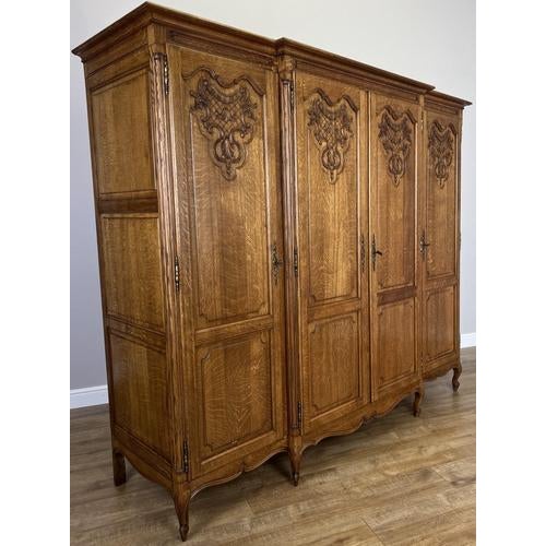This elegant Vintage French Louis wardrobe features beautifully figured oak and refined carved detailing that reflects...