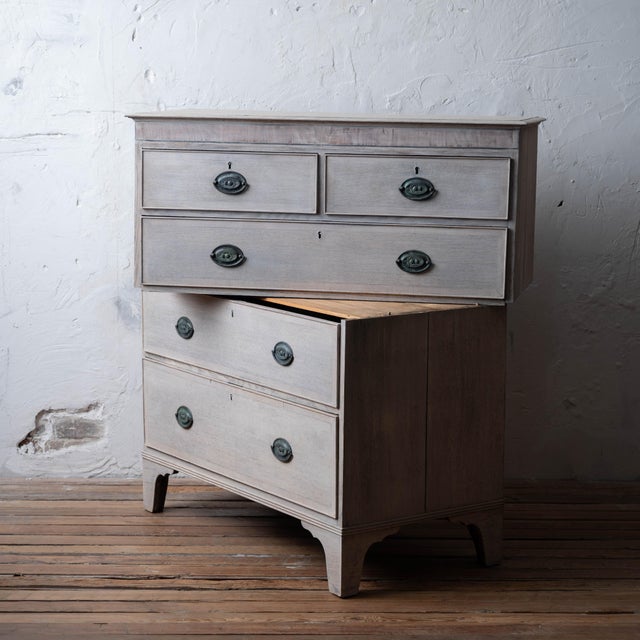 Georgian oak chest of drawers in two sections with mahogany crossbanded frieze, blue sugar paper lined interiors, and oval...