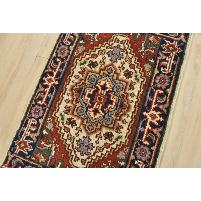 A traditional tribal Heriz rug hand-knotted with an all-wool pile on a cotton foundation. This oriental rug features a...