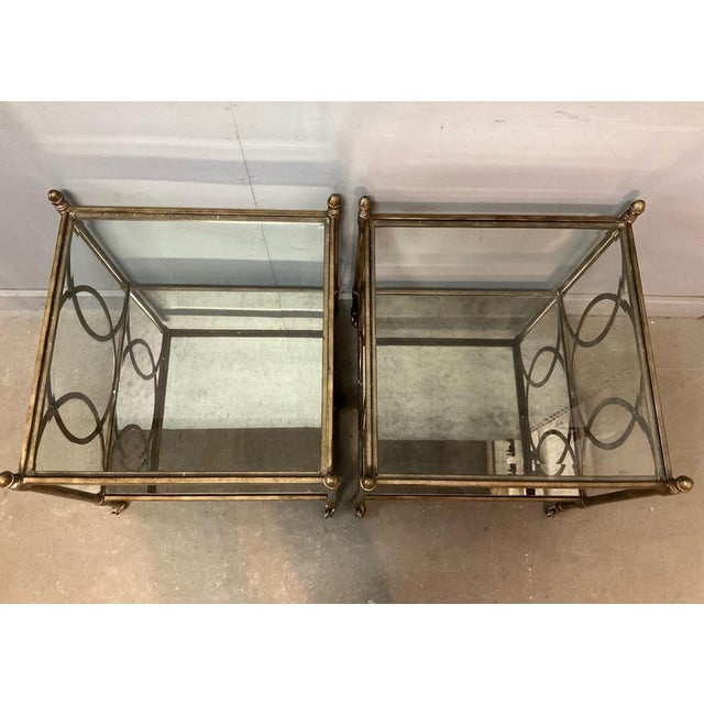 Calling all Hollywood Regency lovers! This pair of vintage two tiered gold tone metal and glass side tables will be a...