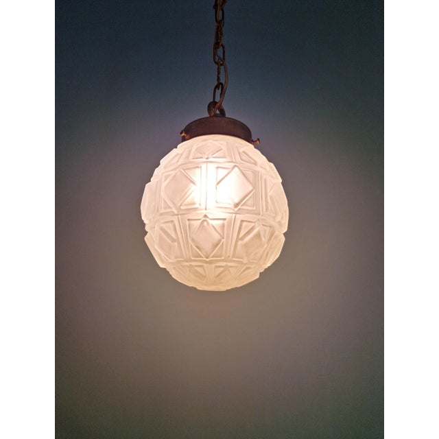 Art Deco pendant light in frosted molded pressed glass with a brass mount, 1930s. The pendant is compatible with a B22 LED...
