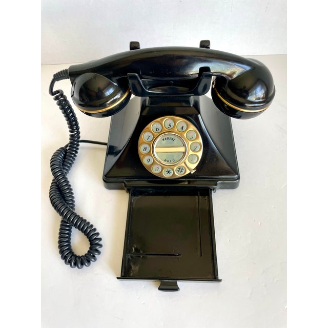 Here is a vintage-inspired rotary style desk telephone in a classic black finish with warm brass-tone dial detailing....