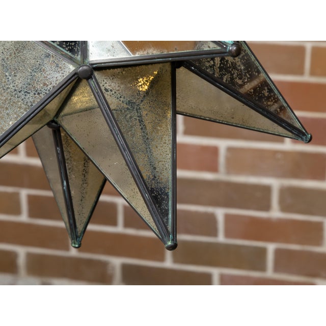 A small French star shaped light fixture from the Midcentury period, with antiqued mirrored panels and single socket. This...