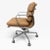 A classic Eames Soft Pad Management Chair upholstered in warm camel brown leather with a polished aluminum frame. The...