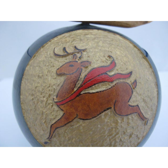 Hand painted and carved dried gourd featuring a carved prancing deer with red scarf. Natural driftwood handle attached to...