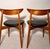 A handsome pair of Danish modern teak dining chairs dating to the mid-20th century. The chairs feature sculptural crescent...
