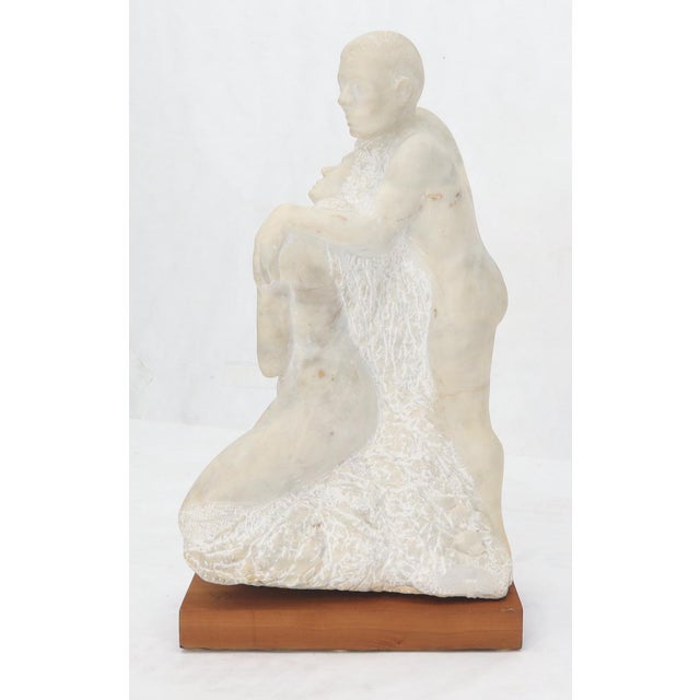 Carved marble sculpture of hugging nude male and female.