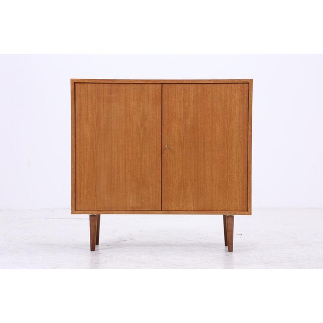 Vintage chest of drawers from WK Möbel with clean proportions and beautiful teak grain. The spacious interior with a shelf...