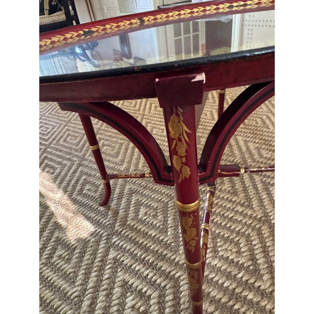 A beautiful rich vibrant red Tole table Circa 1820 with gilded flowers and leaves on a modern painted wooden stand....