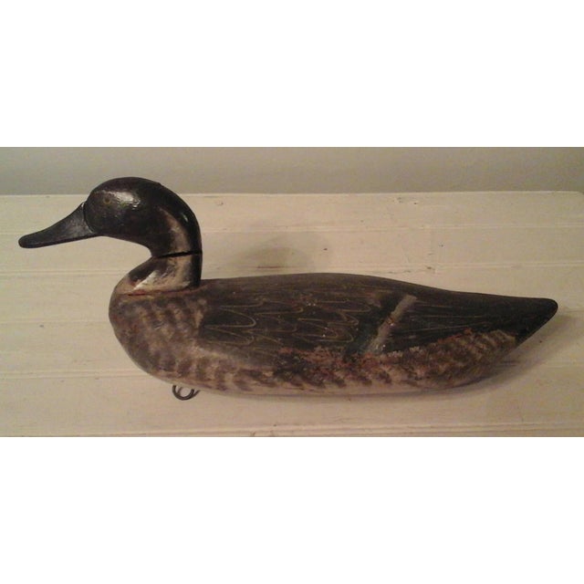 A magnificent and rare early vintage wooden duck decoy, featuring a distinct swivel-head construction. This museum-quality...
