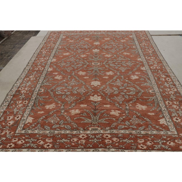 Hand-knotted in wool, this 8x11 17th century Antique Mogul rug has a red field with notes of pink, brick, salmon, or even...
