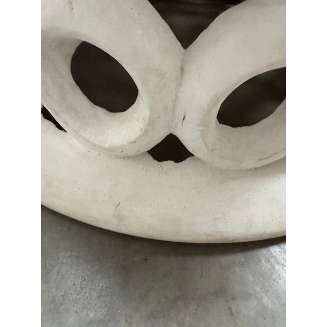 A round coffee table with curved, ring-like forms that create a bold, sculptural silhouette. Crafted entirely from...