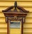 This is a Theodore Alexander 62 inch neoclassical style carved mahogany and gilt wall mirror with shelves and bracket....