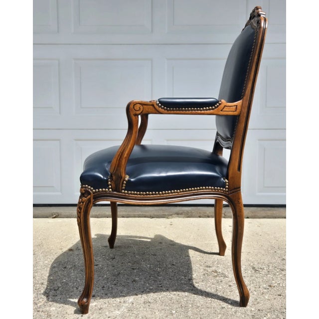 Outstanding carved frame arm chair with dark Blue leather upholstery with brass nail head trim. Produced by Chateau D'Ax...