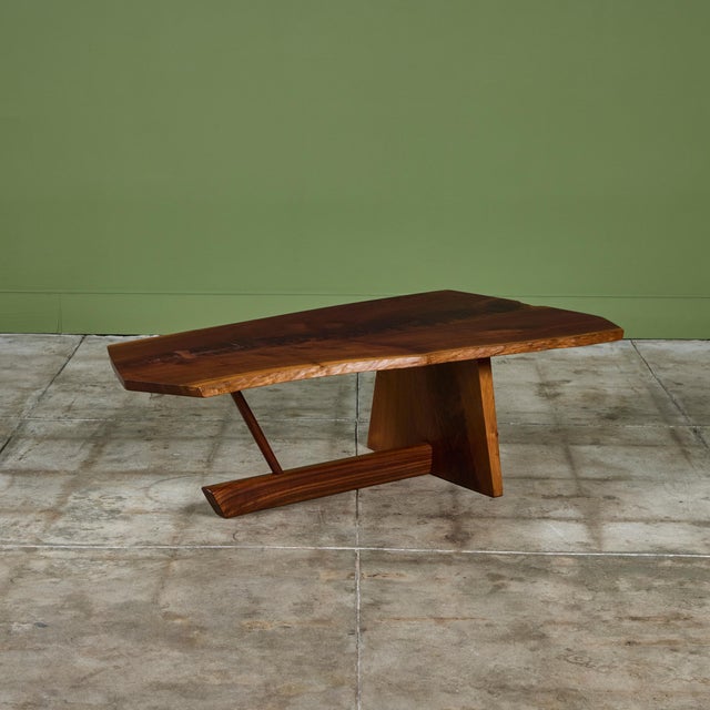 Coffee table from American mid-century craftsman George Nakashima. The table crafted of black walnut, c.1988 features a...