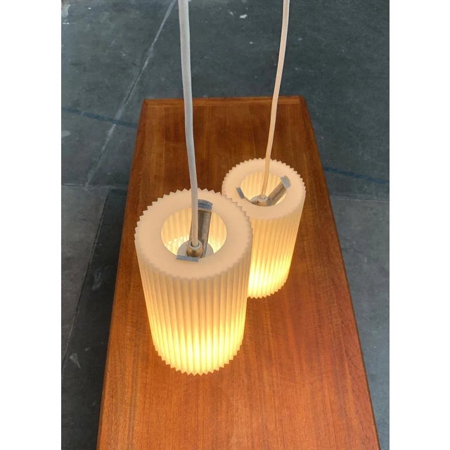 Sleek Mid Century pendant lights from Erco. A minimalist design. The diffusers are made of plastic and fluted all around....