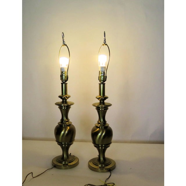 These heavy brass lamps were created in the 1960s. They have smooth classic lines that will fit any design you pair them...