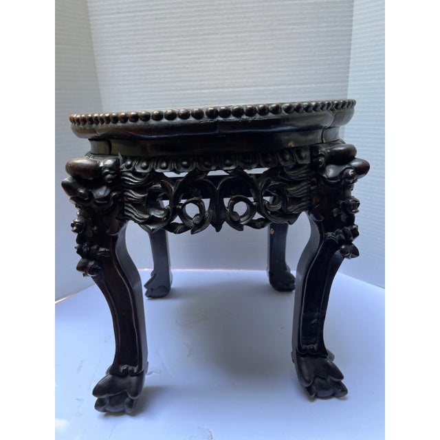 A single antique Chinese carved hardwood stand or table with inset marble top and four legs.