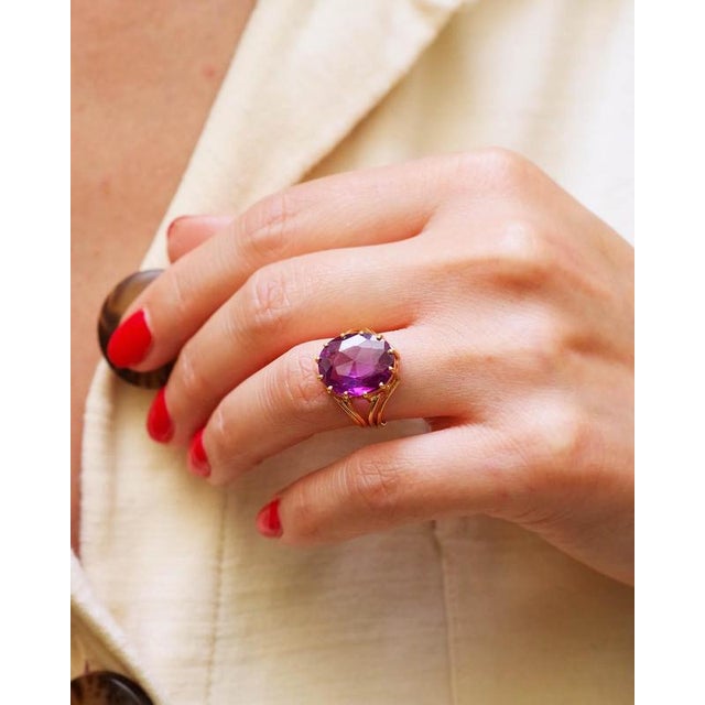 Vintage cocktail ring in 18 karat gold. Vintage ring adorned with a large faceted oval synthetic sapphire, purple in color...