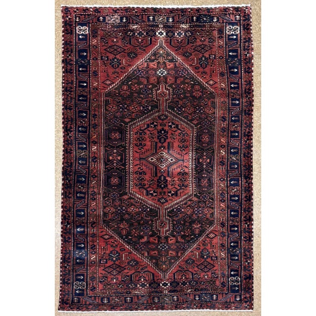 Antique hand-knotted rug from the Hamedan region of western Iran, featuring a large central hexagonal medallion enclosed...