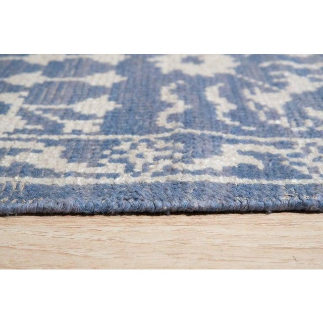 This hand knotted pile rug features a primary blue color palette and is crafted from a blend of wool and bamboo silk....