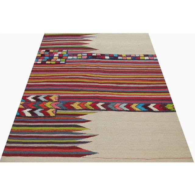 This bewitchingly beautiful example of a tribal Kilim area rug features a contemporary pop of electrifying bright colors...