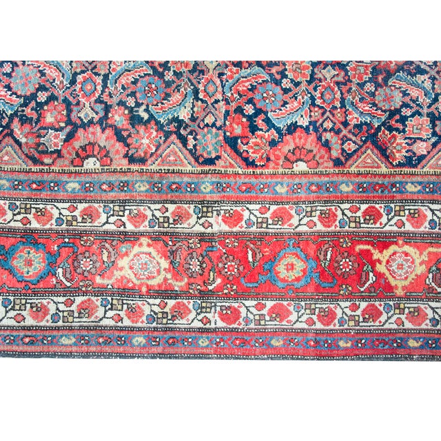 This antique Persian Malayer rug, dating to the 1920s, features a large, intricate navy blue central medallion set against...