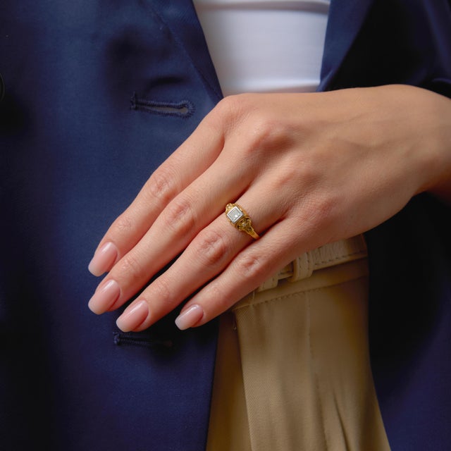 This elegant vintage engagement ring showcases a clean and timeless princess cut diamond, offering a crisp, modern...